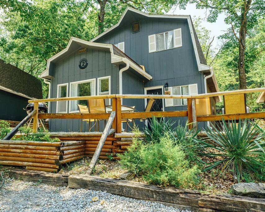 a gray house with a wooden fence in front of it at Tribesman Resort #2 on Table Rock Lake by Silver Dollar City in Branson