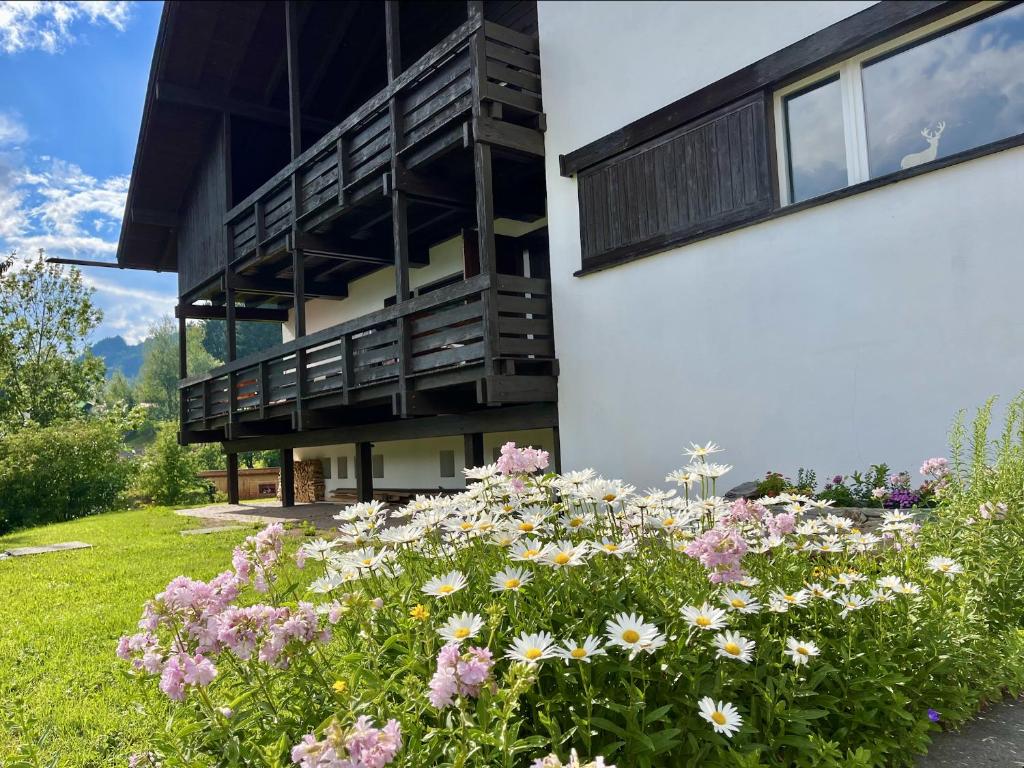 a building with a bunch of flowers in front of it at Mountain Chalet Tre Marie in Cavalese
