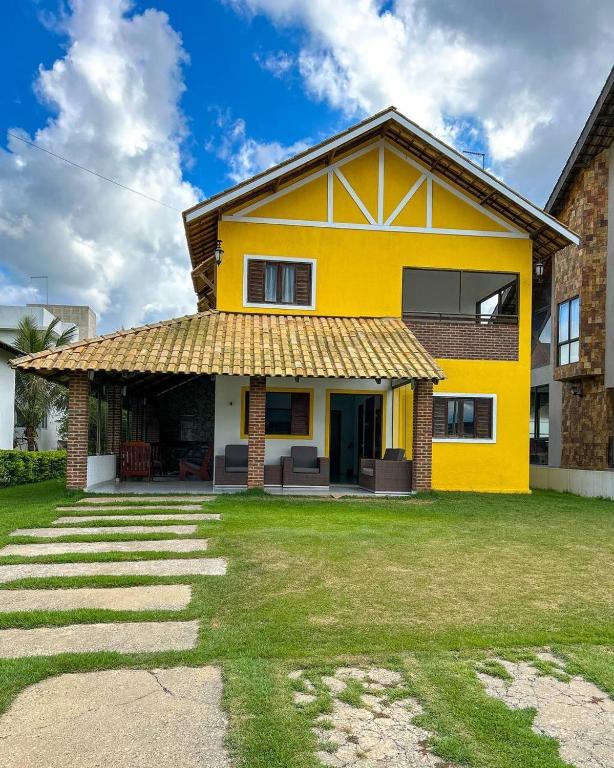 a yellow house with a grass yard at Casa em Bananeiras PB in Bananeiras