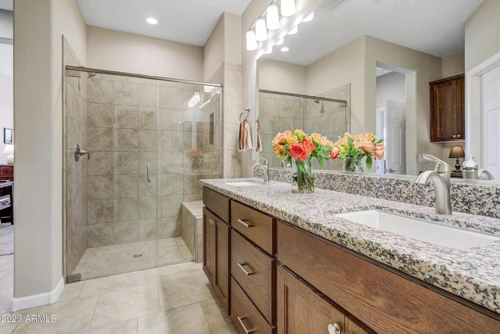 a bathroom with a shower and a sink with flowers at Upscale Fully Furnished Resort Home-Gated Golf Community in Rio Verde