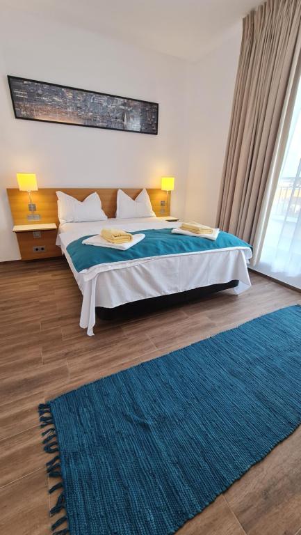ein Schlafzimmer mit einem großen Bett und einem blauen Teppich in der Unterkunft Jafar Resort 9 Penthouse in Timişoara