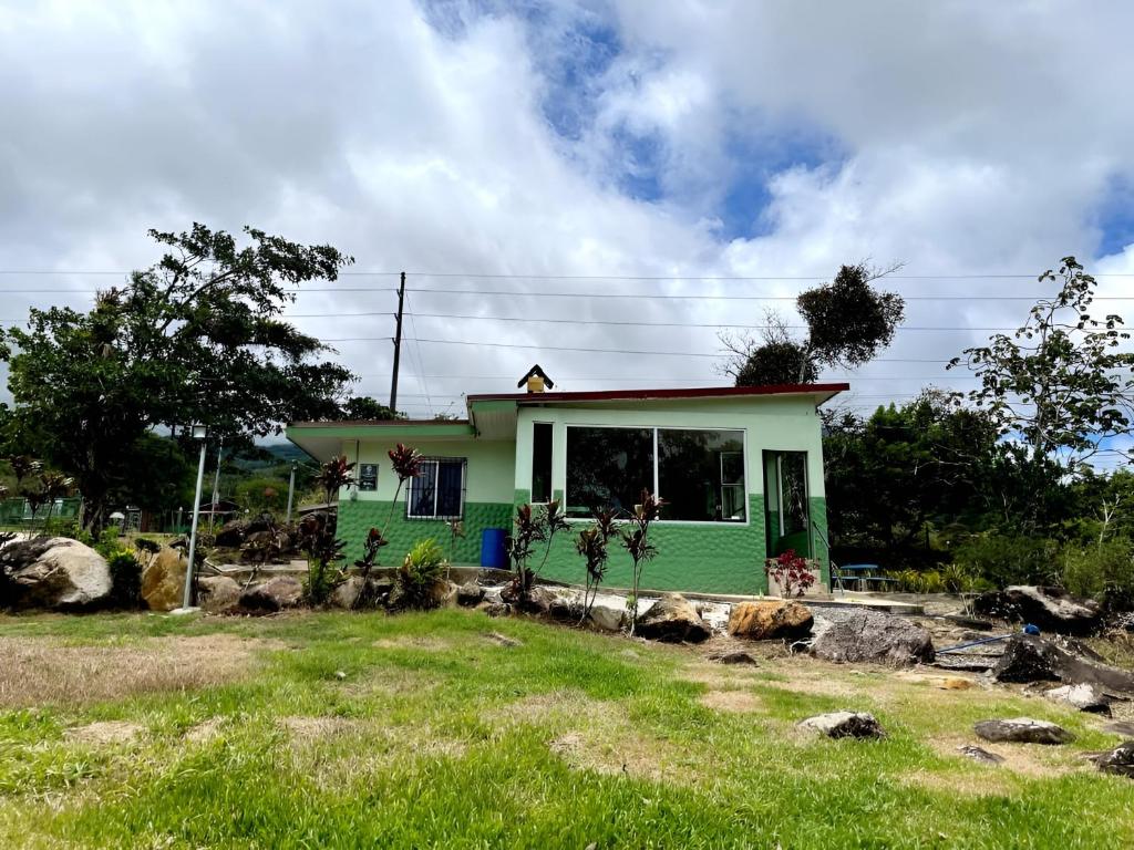 a small house with a green exterior at Miravalles Volcano House in Guayabal
