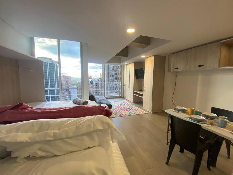 een slaapkamer met een bed en een bureau met uitzicht bij Loft con vista 180° en Centro Internacional 1224 in Bogota