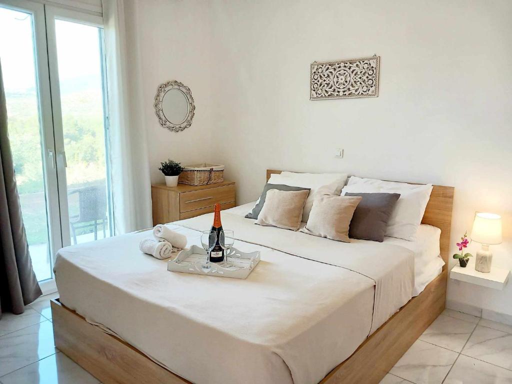 una camera da letto con un grande letto bianco e una bottiglia di vino di 4T apartments ad Argostoli
