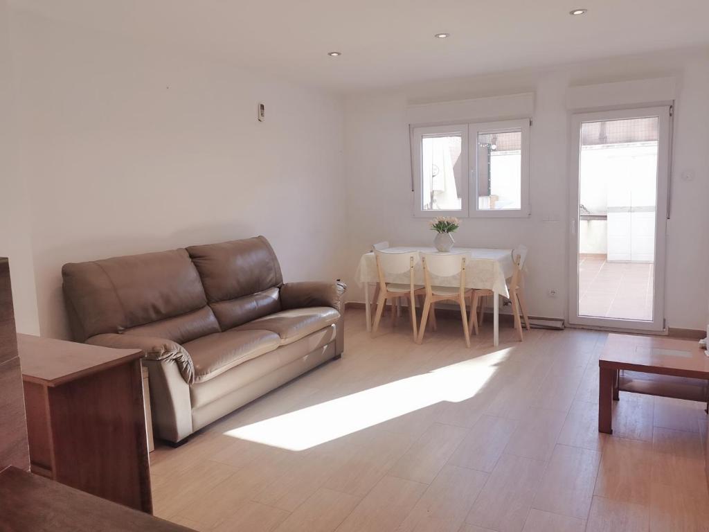 uma sala de estar com um sofá e uma mesa em Villa con patio em Madri