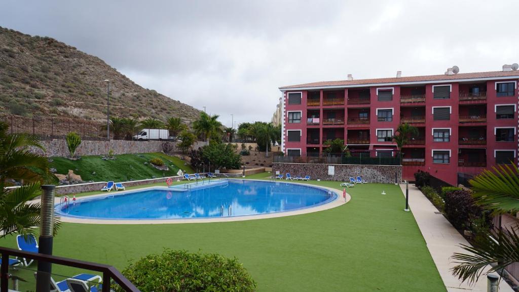 a large swimming pool in front of a building at Cómodo apartamento en El Palm mar in Palm-Mar