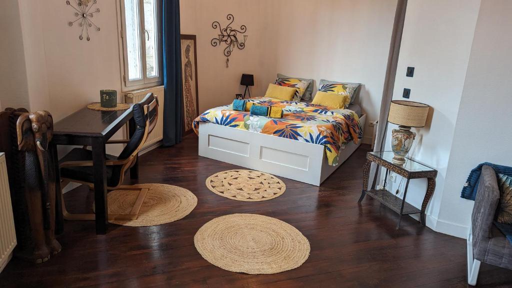 a bedroom with a bed and a desk and a table at Charmante maison proche Hôtel de ville in Angoulême