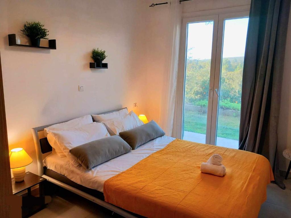 a bedroom with a large bed with a large window at 4T apartments in Argostoli