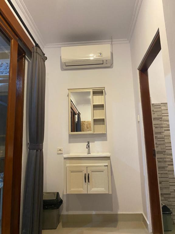 a bathroom with a sink and a mirror at Tirta Kemala House in Ubud