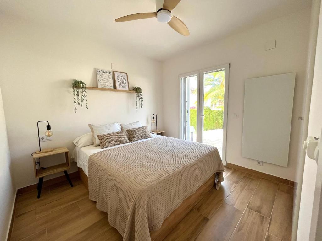 Un dormitorio con una cama y un ventilador de techo. en Bungalow en Denia, en Denia