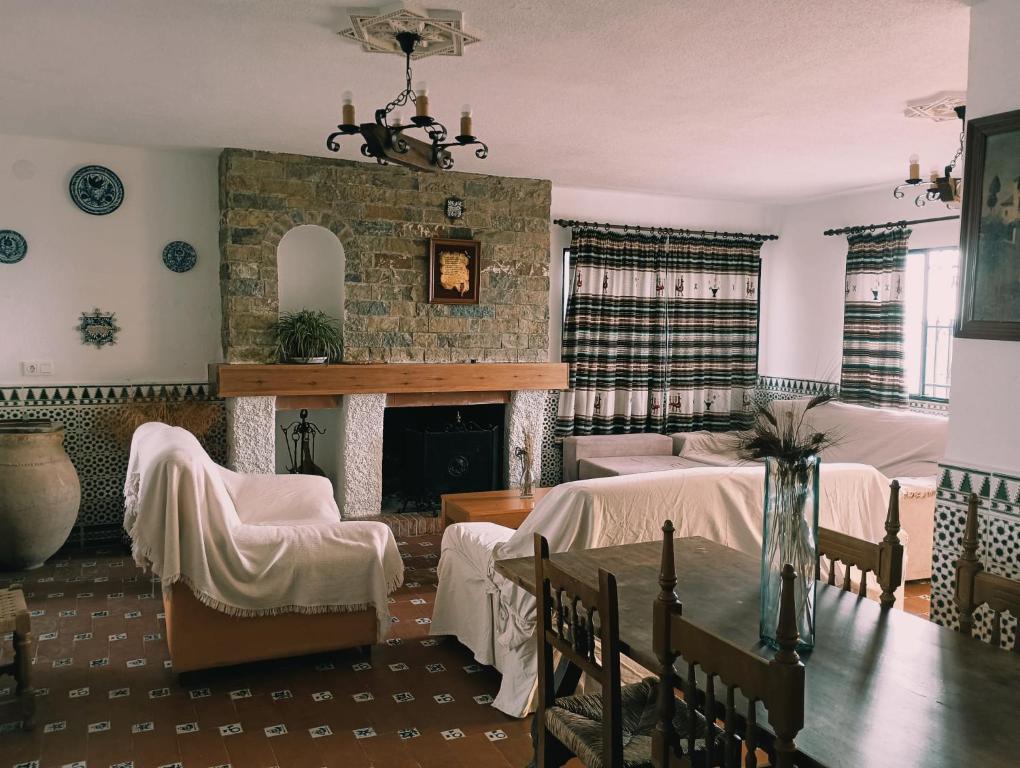 sala de estar con chimenea, mesa y sillas en Casa los Huertecillos, en Nívar