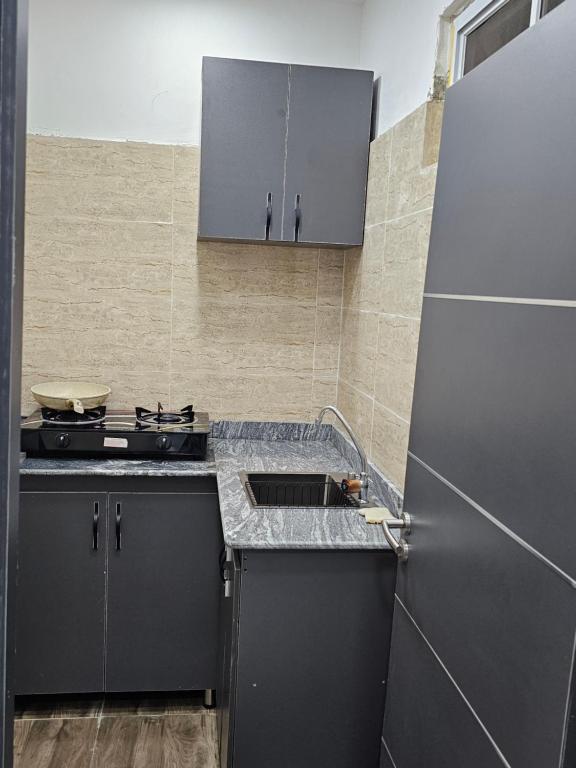 a kitchen with a sink and a refrigerator at Hencapservices 001HPS in Agege