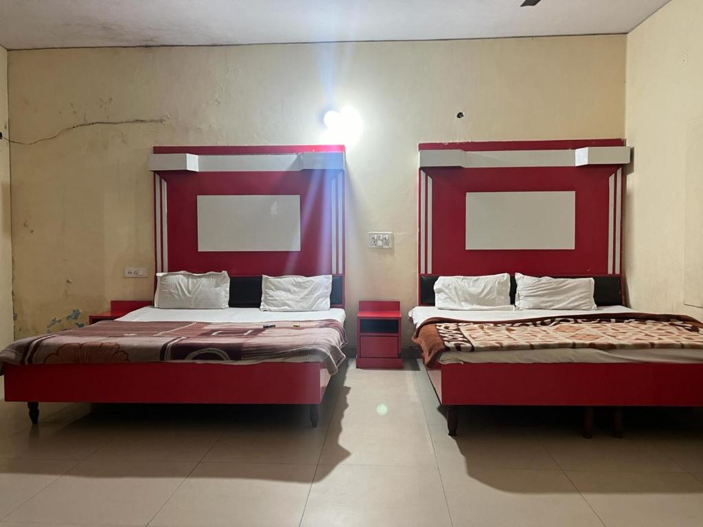 two beds in a room with red headboards at Hotel Skylark in Amritsar
