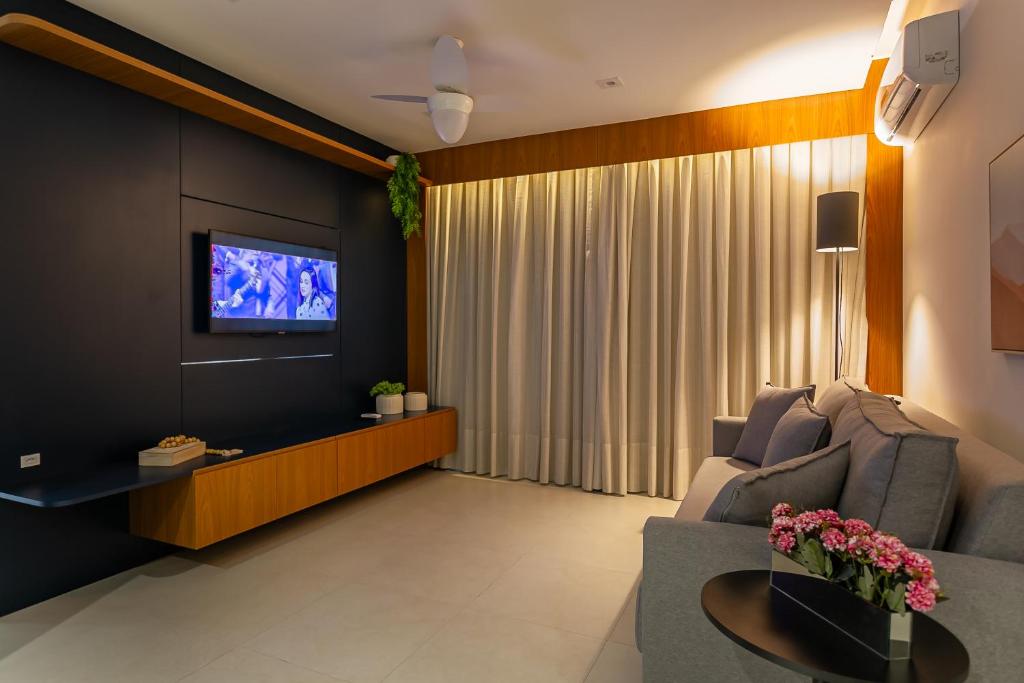 a living room with a couch and a tv at Confortável Studio com 46,72m² in Florianópolis