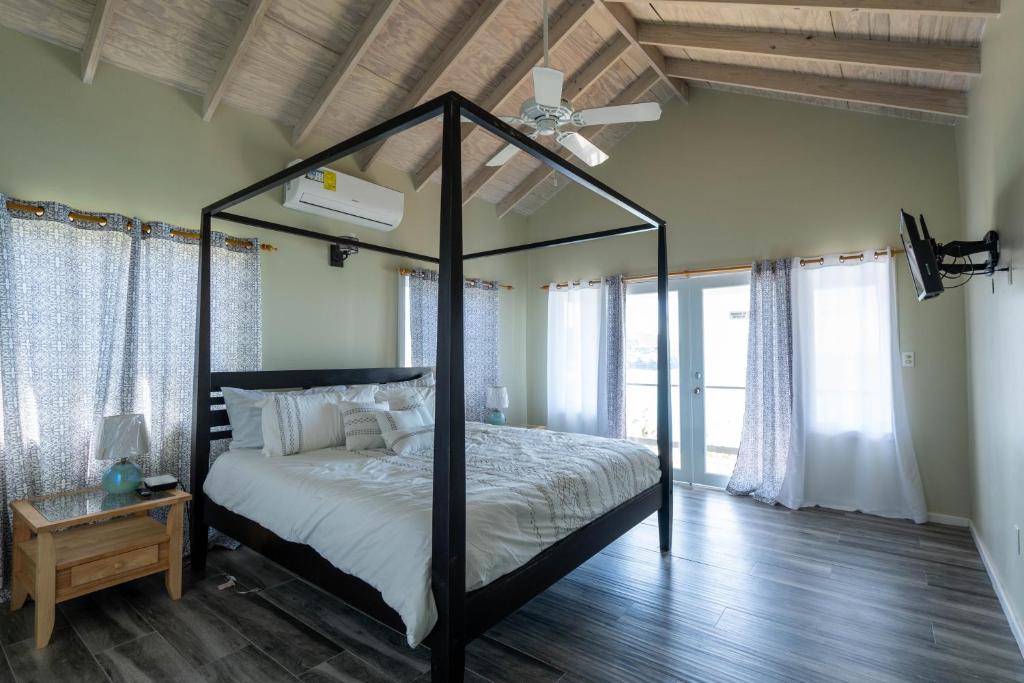 a bedroom with a canopy bed with a ceiling fan at The Ti-Kaye Oasis in Crab Hill