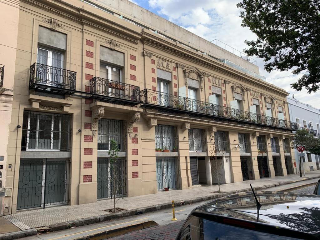 - un bâtiment avec balcon sur le côté d'une rue dans l'établissement Lezama Park, à Buenos Aires