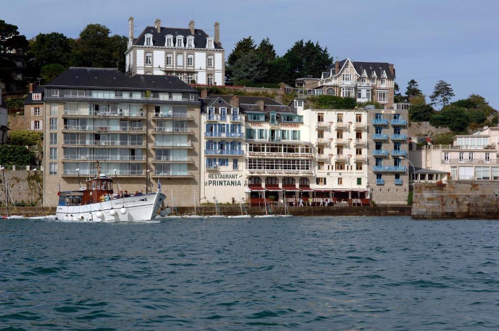 boats are docked in the water near a large building at Hôtel-Restaurant Printania in Dinard
