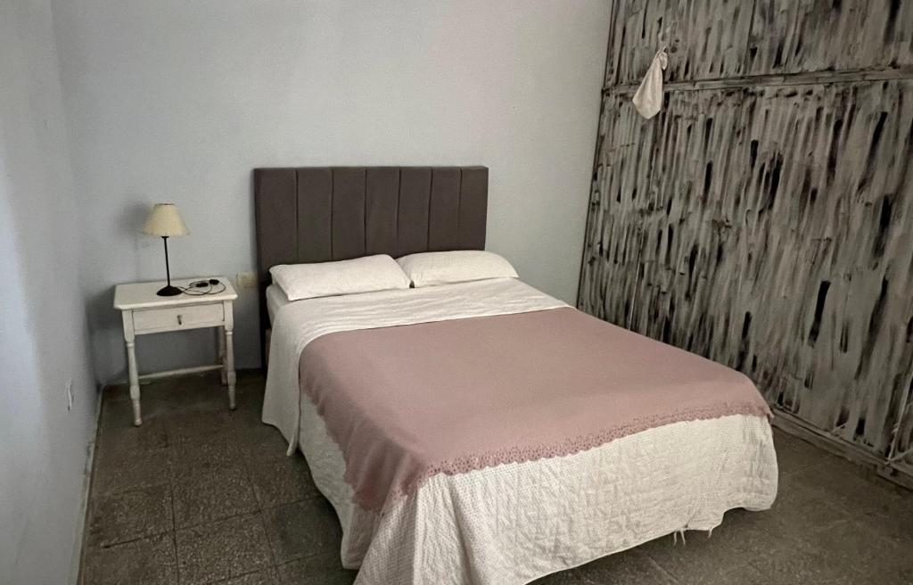 耶爾瓦布埃納的住宿－Chalet en YB，一间卧室配有一张床和一张带台灯的桌子