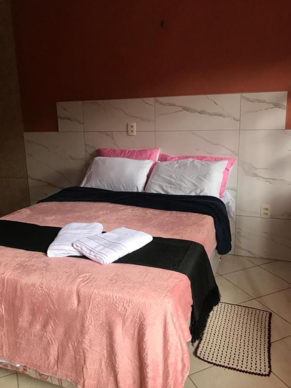 - un lit avec des draps roses et noirs et des oreillers blancs dans l'établissement Suíte na serra, à Guaramiranga