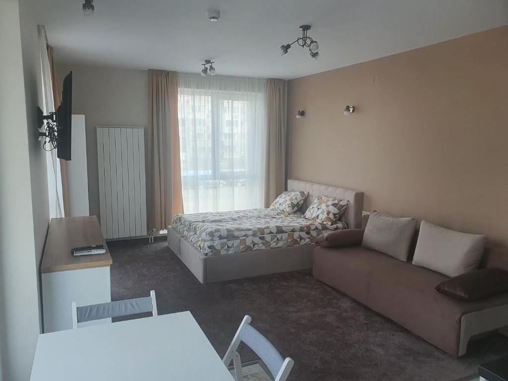 a living room with a bed and a couch at Димоти Апартхотел in Sofia