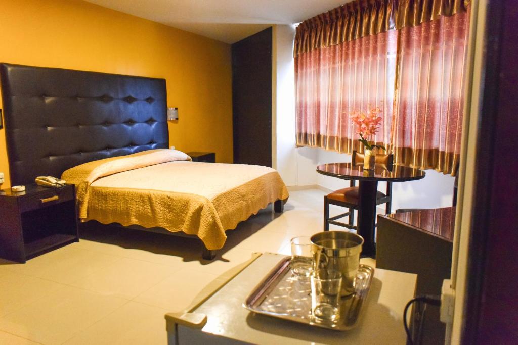 Un dormitorio con una cama y una bandeja en una mesa. en Gran Hotel Canada en Santa Cruz de la Sierra