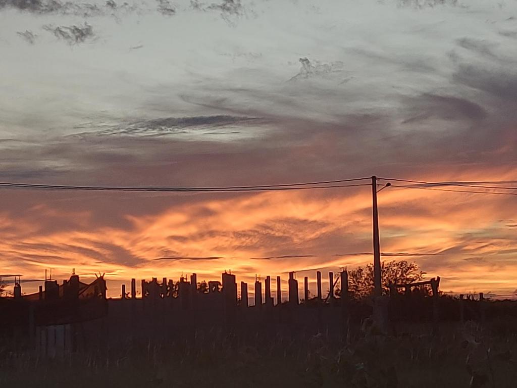 una puesta de sol sobre una ciudad con una valla en Lugar tranquilo e aconchegante, en Tibau do Sul