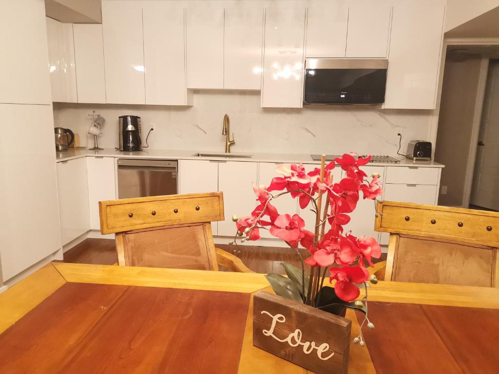 a kitchen with a table with a vase with flowers at JESI'S NEW HOUSE, Self Enter 2BR, Whole Suite, Close to White Rock Beach & US Border in Surrey