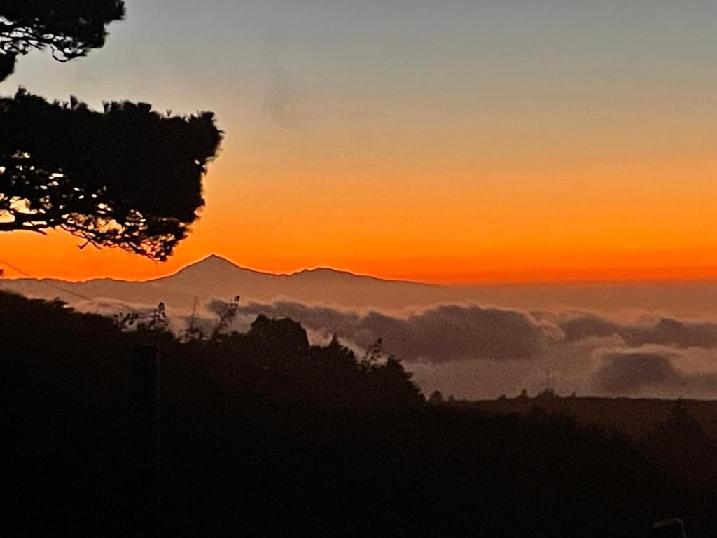 een zonsondergang in de bergen met een laag wolken bij Escape to the country - Casa de Lorenzo, El Hierro in San Andrés