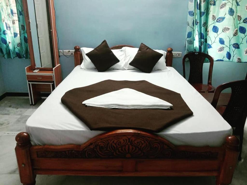 a bed with a brown blanket on top of it at Sunshine Beach House in Navalur