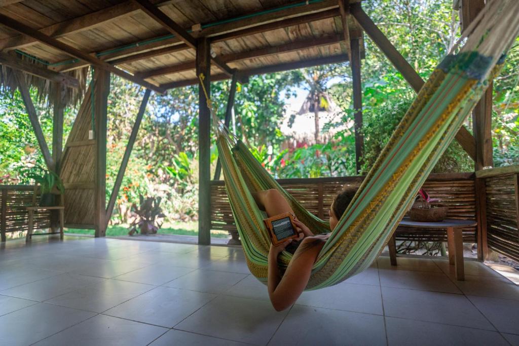 a child laying in a hammock with a cell phone at Casa Moringa in Palomino