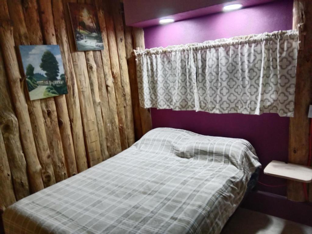 małe łóżko w drewnianym pokoju z oknem w obiekcie Las escondidas w mieście Pueblo Nuevo