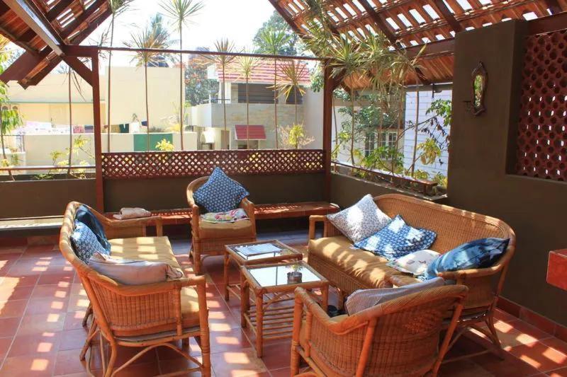 a patio with a couch and chairs and a table at Jugglers Rest 4 Sharing in Bangalore