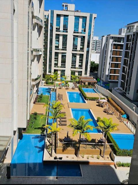 an overhead view of a pool with palm trees and buildings at Confortável Studio no Park Sul próximo ao aeroporto in Brasília