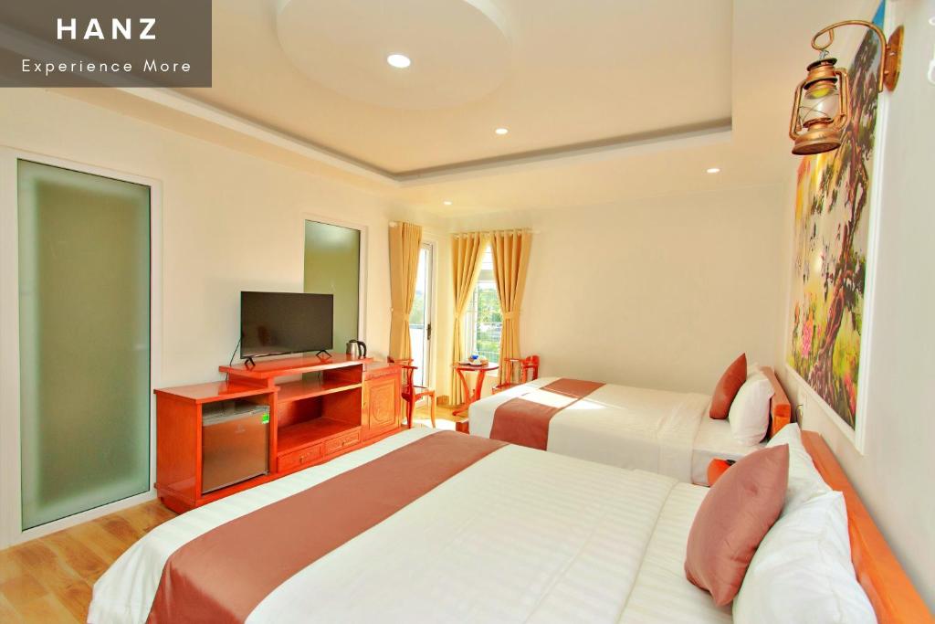 a hotel room with two beds and a television at HANZ HOPAPA Hotel Phu Quoc in Phu Quoc