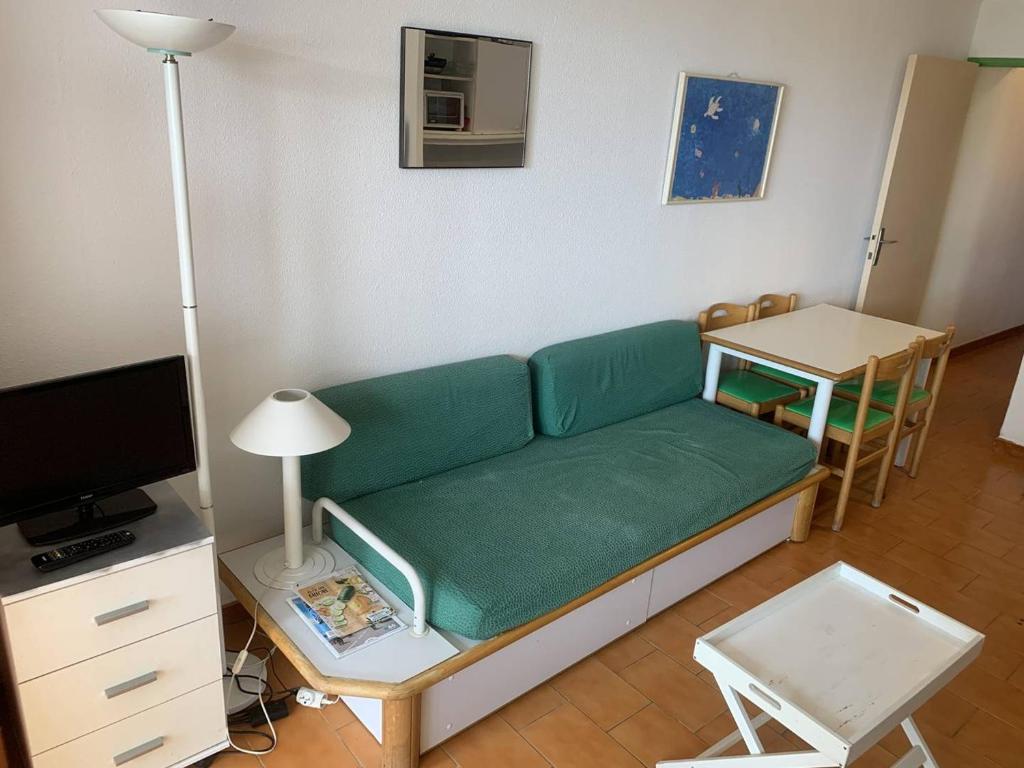 ein Wohnzimmer mit einem grünen Sofa und einem Tisch in der Unterkunft Appartement Sainte-Maxime, 2 pièces, 4 personnes - FR-1-768-68 in Sainte-Maxime