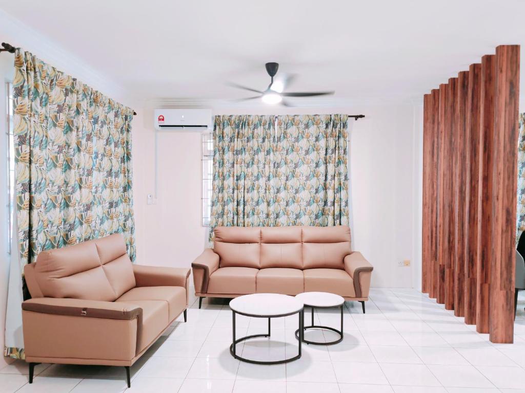 een woonkamer met 2 stoelen en een tafel bij Richmond Residence in Kuching