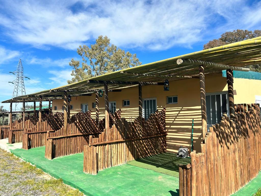 ein Haus mit einem Holzzaun davor in der Unterkunft Posada campo bello in Quebracho