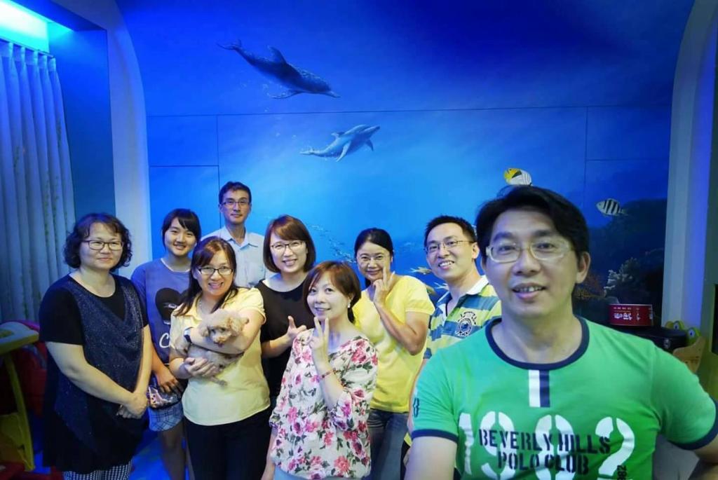 a group of people posing for a picture in front of a shark at Fish House 宜蘭獨棟別墅 戲水池 生態DIY 安農溪自行車 in Dongshan