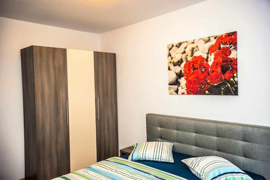 1 dormitorio con 1 cama y una pintura en la pared en Adara Mamaia Nord, en Mamaia Nord – Năvodari