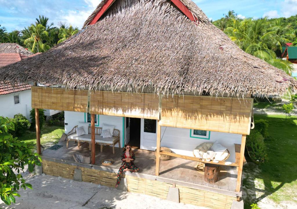 - une vue aérienne sur une cabane au toit de chaume dans l'établissement Mentawai Katiet Beach House, Lance's Right HTS, à Katiet