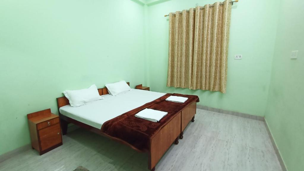 Un dormitorio con una cama grande y una ventana en ARJUN PAYING GUEST HOUSE en Ayodhya