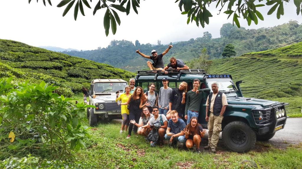 un grupo de personas posando para una foto en la parte superior de un vehículo en A3A Oastel coLiving en Tanah Rata