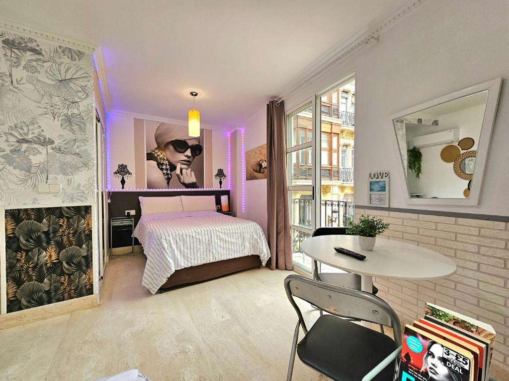 a bedroom with a bed and a table in a room at Loft Pasarela in Alicante
