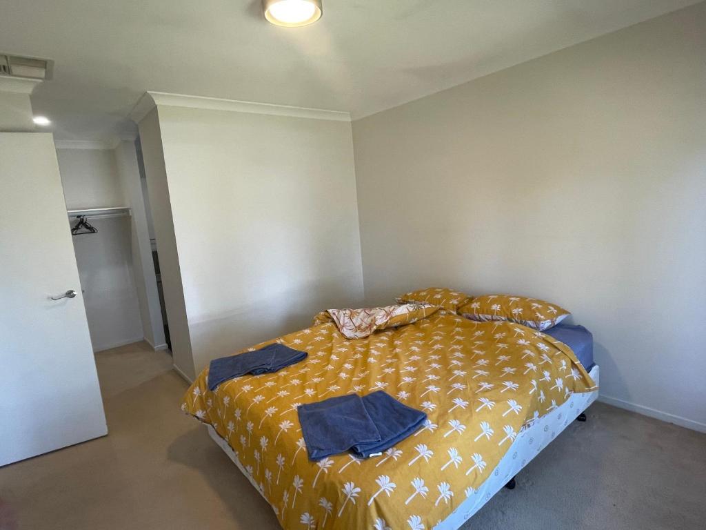a bedroom with a bed with a yellow comforter at Elegant master bedroom with private bathroom in Point Cook