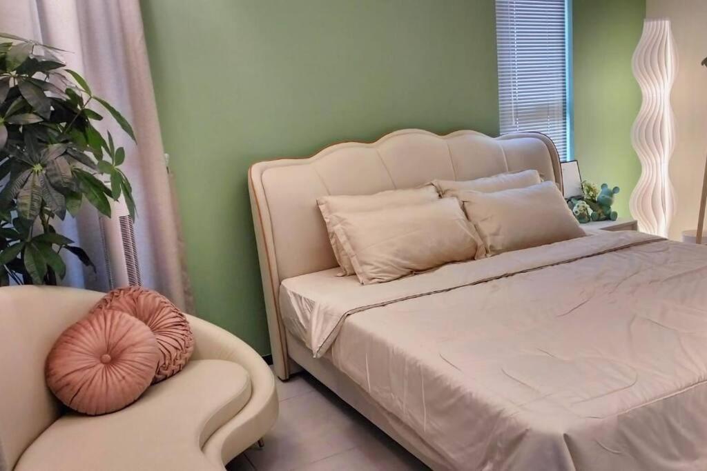 ein Schlafzimmer mit einem weißen Bett und einem Stuhl in der Unterkunft Romantic Sea View @ Urban Suite in Jelutong