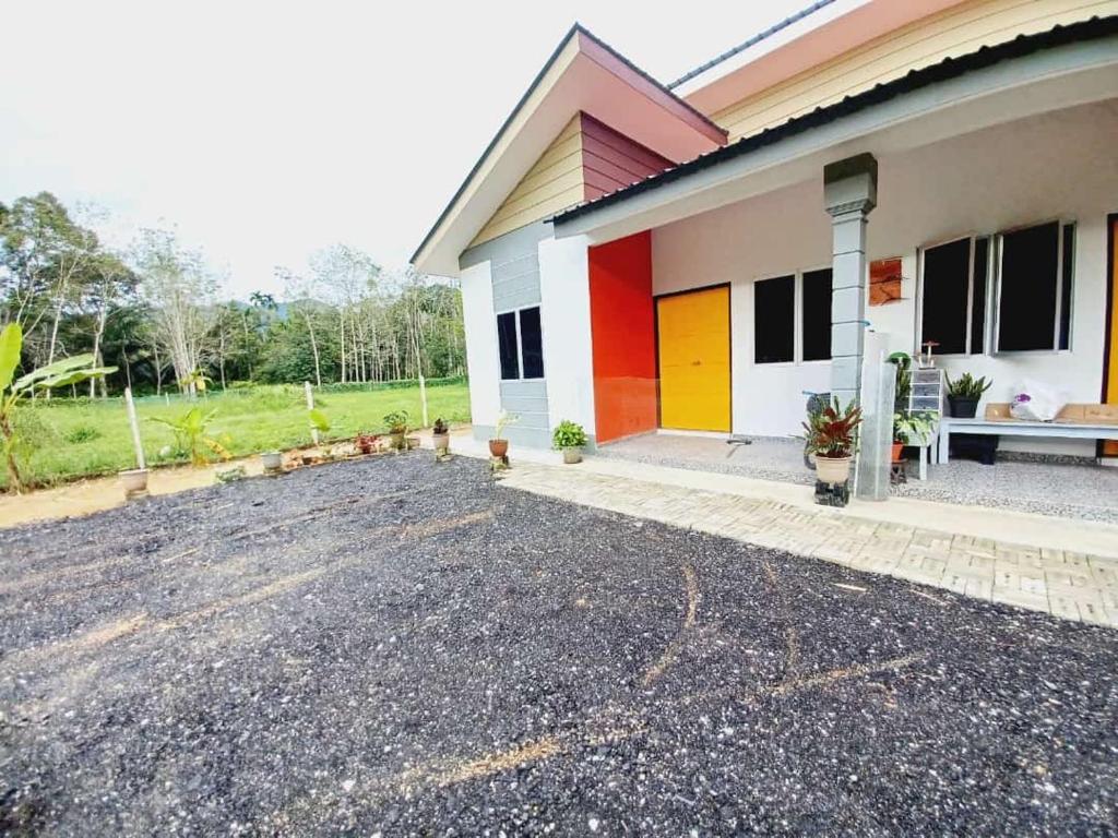 Aufa House في Padang Rengas: منزل به أبواب ملونة على الجانب منه