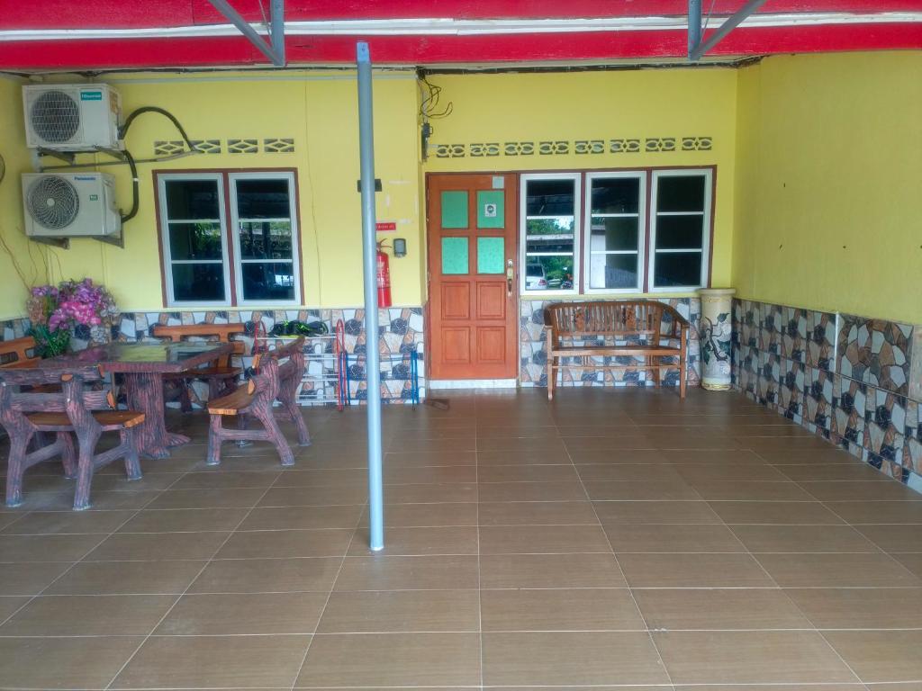 un restaurante con puerta roja, mesas y sillas en MieHomestay Binjai Rendah, en Bukit Payong
