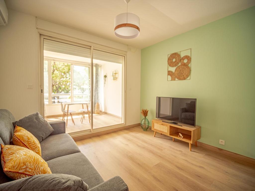 a living room with a couch and a flat screen tv at studio cosy - champ fleuri in Sainte-Clotilde