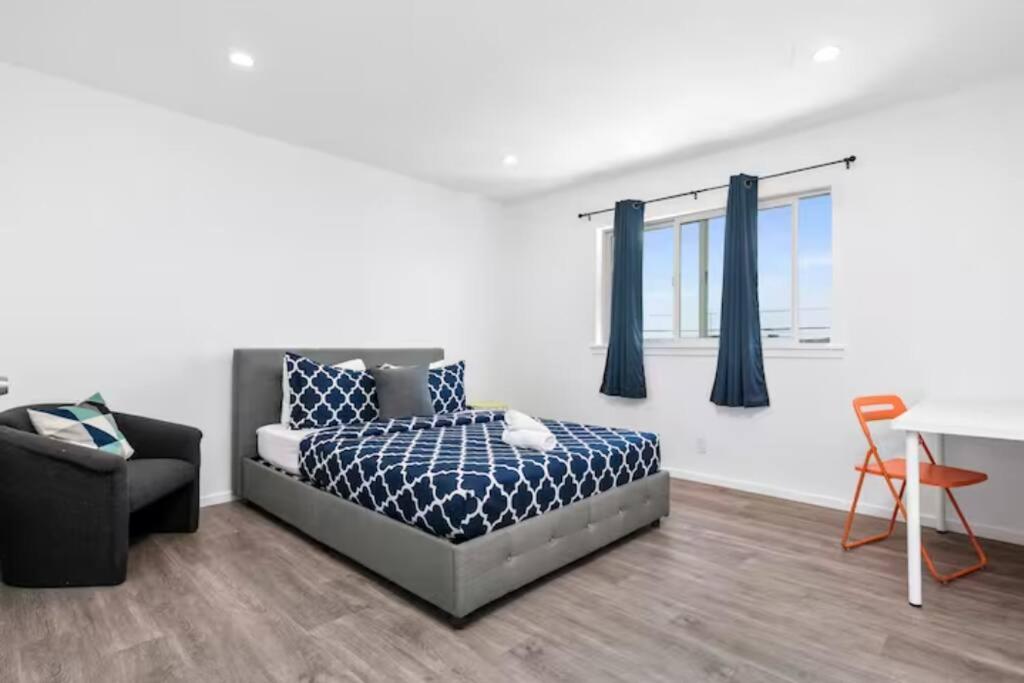 a bedroom with a bed and a chair and a table at Newly Remodeled Cozy 2BR or 3BR Apartment in Tanforan, block away from CalTrain, near SFO in San Bruno