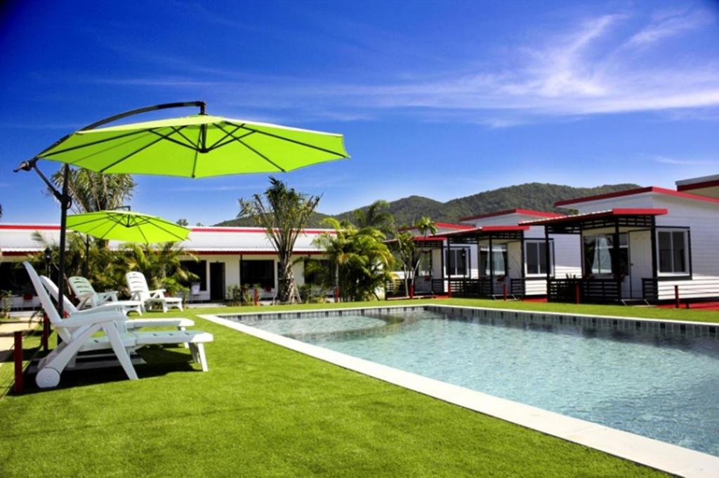 una piscina con sedie e ombrellone accanto a una casa di Cape Go Resort a Chao Lao Beach